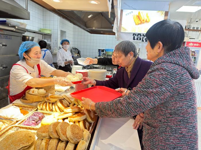 　　老人排队取饭菜。内蒙古日报记者 肖璐/摄