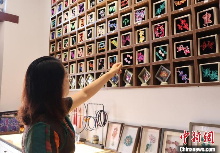图为孙艳正在挑选盘扣纹样。杨馥宁 摄