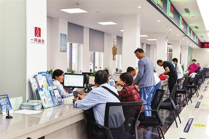     办事群众在上海市嘉定区外冈镇社区事务受理服务中心“一网通办”窗口办理事项  李明霞  摄