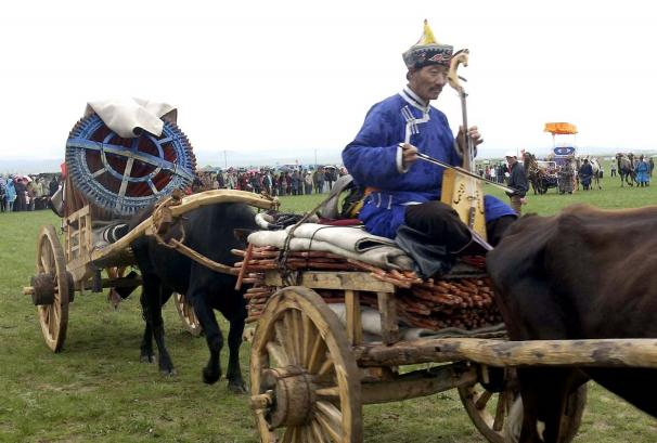 乌兰牧骑演员乘坐牛车在赤峰市克什克腾旗那达慕大会上进行流动表演。（2002年6月28日发）新华社记者 张领 摄