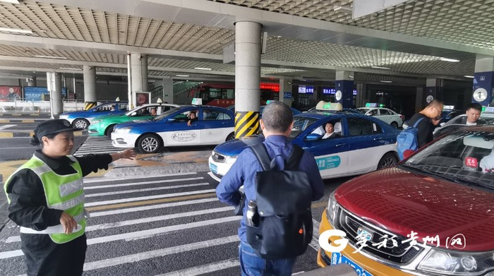 工作人员引导旅客乘坐出租车
