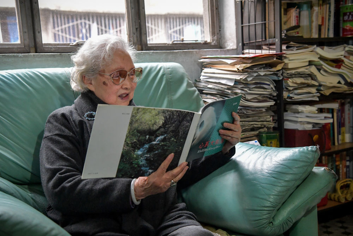 2018年11月27日，金勖琪在四川成都的家中翻看印有她拍摄的照片的画册。新华社记者 张超群 摄