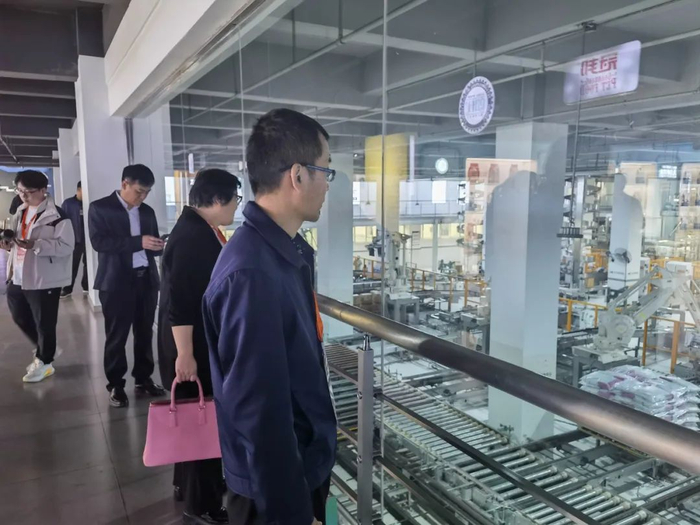 在华兴宠物食品有限公司，嘉宾正在参观生产车间。郭雨晗摄