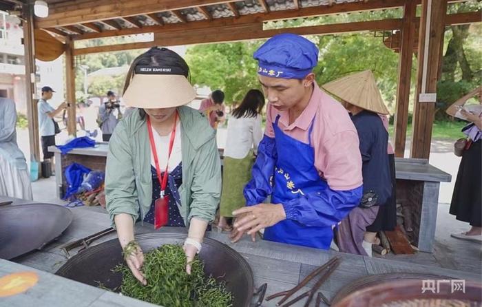 游客正在体验炒茶（央广网记者 梁瑜琳 摄）