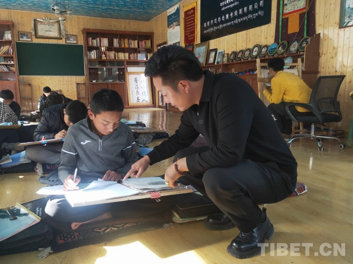 图为嘎玛斯加在指导学生练习摄影：周晴晴