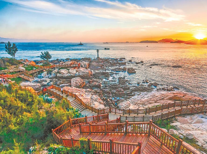 东山县关帝文化产业园位于岵嵝山下，依山临海。图为游客在海边的木栈道观赏日落。（资料图片）