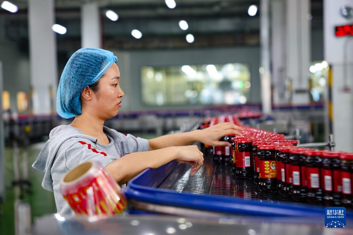   工作人员在老干妈生产线上整理货品（8月20日摄）。新华社记者 刘续 摄