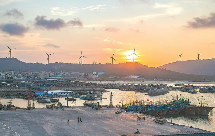 夕阳下,远处的风车与近处的桅樯交相辉映,澳角渔港显得美丽而祥和。