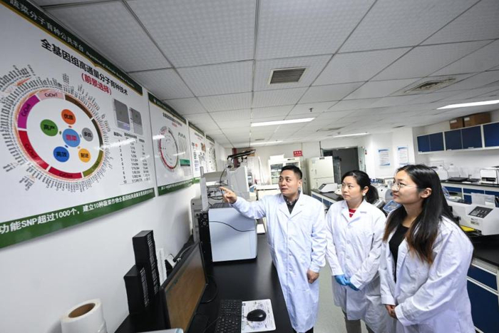 温常龙（左一）在实验室讲解分子育种技术。受访者供图