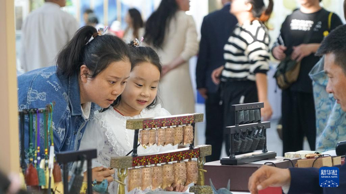 游客在体验敲击编钟。新华社记者 熊翔鹤 摄