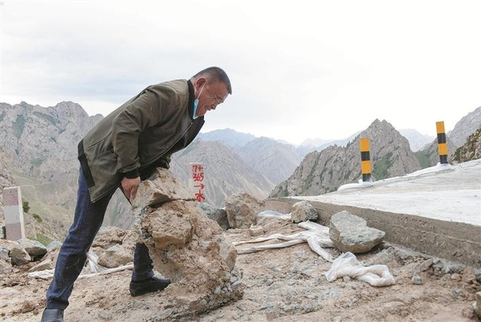     连日降雨造成连队道路塌方，刘前东在现场搬运石块铺路（资料图片）。    兵团日报全媒体记者  陈洋  摄