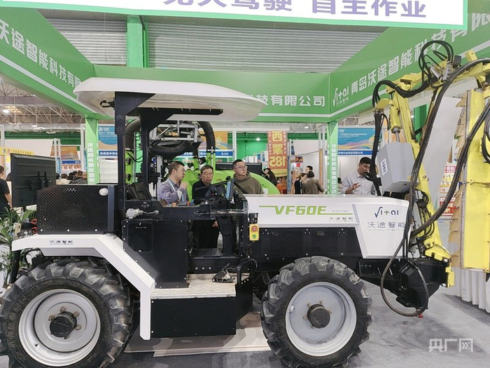 展商观众了解果园全功能智能拖拉机机器人（实习记者  陈钰童  摄）