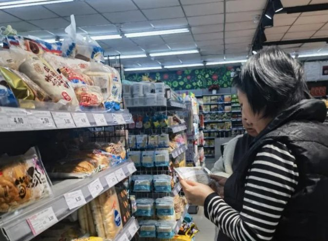 图为消费者在查看面包配料表。