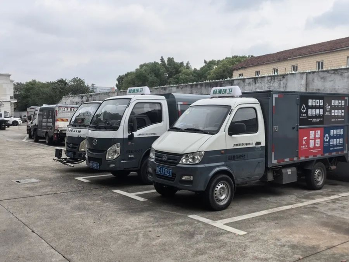 △上海杨浦环境发展有限公司海杰分公司院内，停放着多辆垃圾清运车辆。