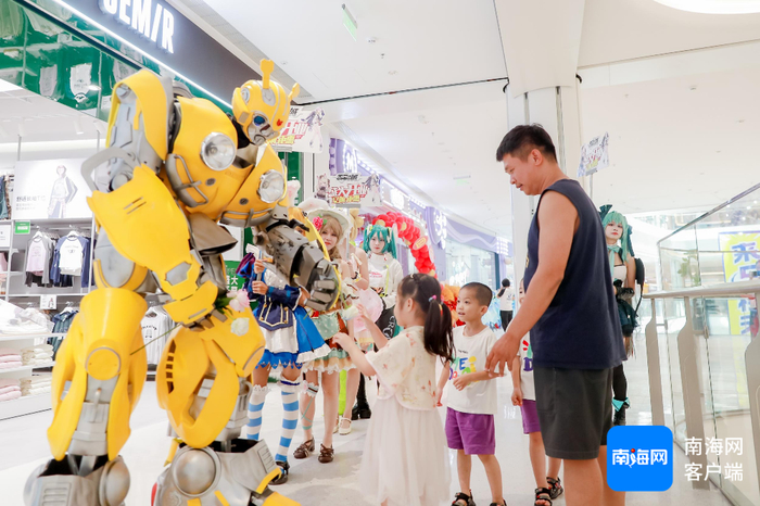 海口天街内门店形象人物与孩童互动。企业方供图