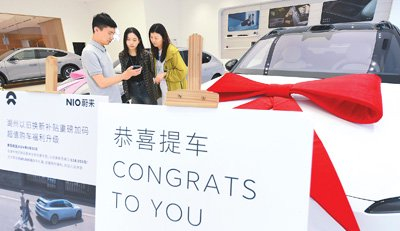 9月24日，在浙江省湖州市湖东街道蔚来交付中心，销售人员向顾客介绍如何申领以旧换新补贴。新华社记者 翁忻旸摄