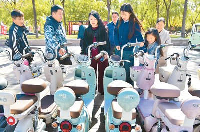 10月19日，山东省枣庄市山亭区举办“汽车、家电以旧换新金秋乐购会”，图为消费者在选购电动车。刘明祥摄（人民图片）