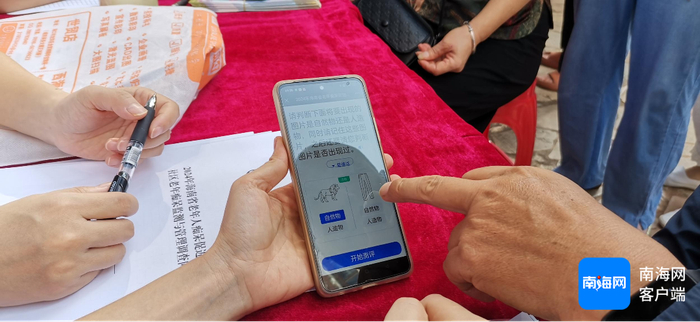 　　海南省人民医院老年专科小组医护人员使用手机APP给社区老人做认知测试。王康景 摄