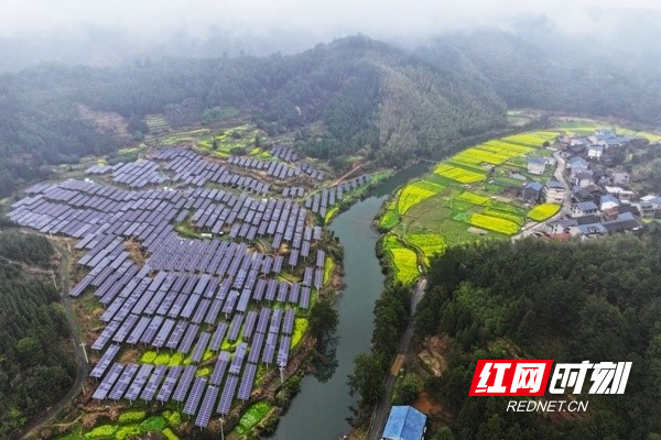 俯瞰湖南省怀化市通道侗族自治县双江镇马家坝光伏发电站，光伏板与田野、河流、乡村，构成了一幅村美人和的新画卷。李尚引 摄