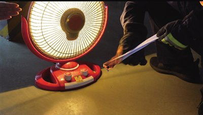 10月29日，消防队员将一张纸条靠近“小太阳”，纸条被引燃。摄影/新京报记者 左琳