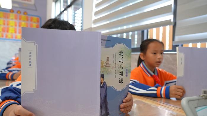 明招小学的学生正在阅读《走近吕祖谦》（央广网发邹欣摄）