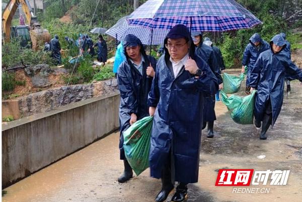 暴雨中运沙固守堤坝。