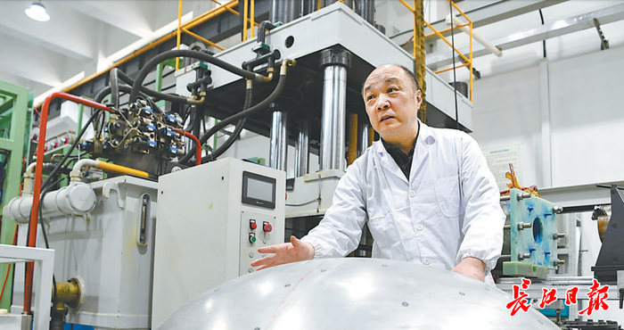 国家脉冲强磁场科学中心主任介绍电磁成型装备制造的壳体构件。  记者高勇 摄