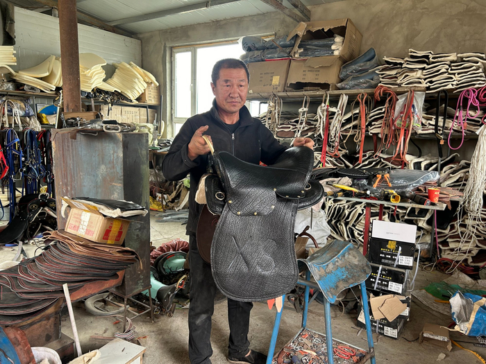 泉子街镇马鞍子制作人丁学生与他制作的马鞍  （任东升  摄）