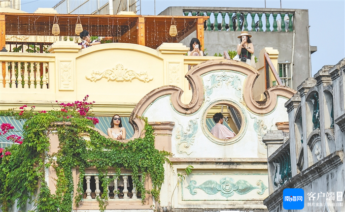 　　游客在海口骑楼老街一家民宿的楼顶拍照留念。海南日报全媒体记者 李天平 摄