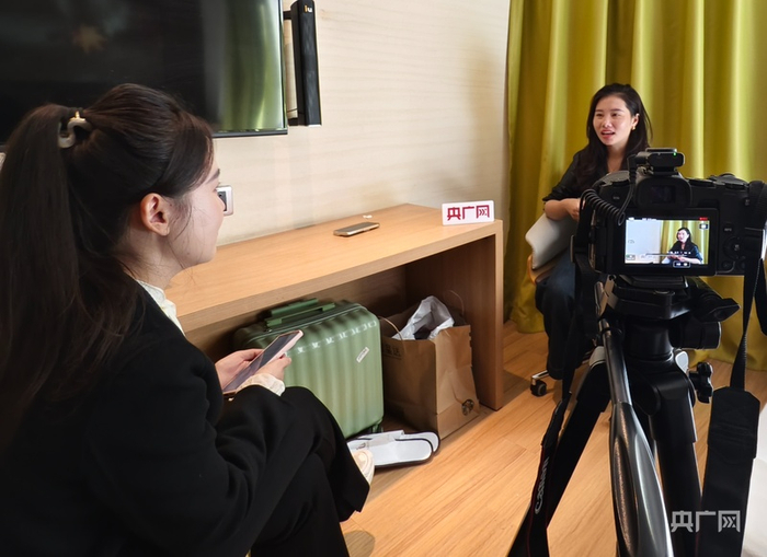 记者栾小琳（左）正在采访杨妞花（右）（央广网记者  任振国  摄）