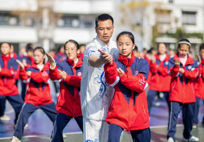黄梅县第一小学，非遗传承人雷超（左）指导学生操练岳家拳。（湖北日报全媒记者 薛婷 通讯员 石勋 摄）