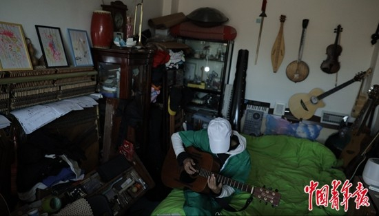     10月10日，刘志勇在家中弹唱。