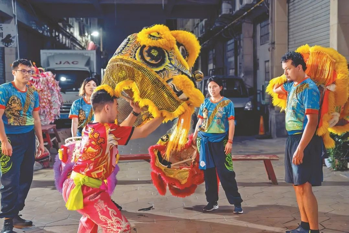 麦旺涛（前）指导秘鲁青年舞狮，左一为阿尔弗雷多。受访者供图