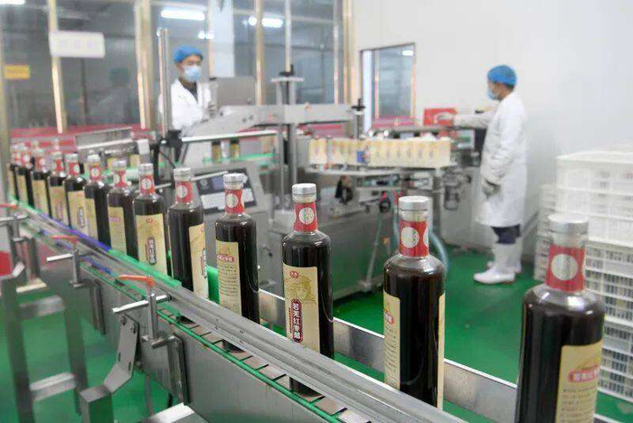 若羌一家农业公司，员工在流水线上生产红枣醋。图源：人民日报客户端