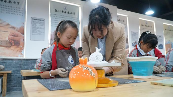 同学们在艺术陶艺社团课堂上学习制作石榴。