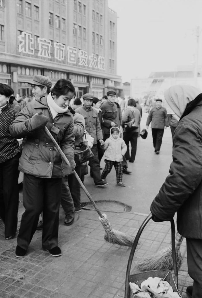 1982年，《北京市市容环境卫生管理规定》公布后，王府井大街的市容卫生监察员帮助清洁工打扫卫生。叶用才摄