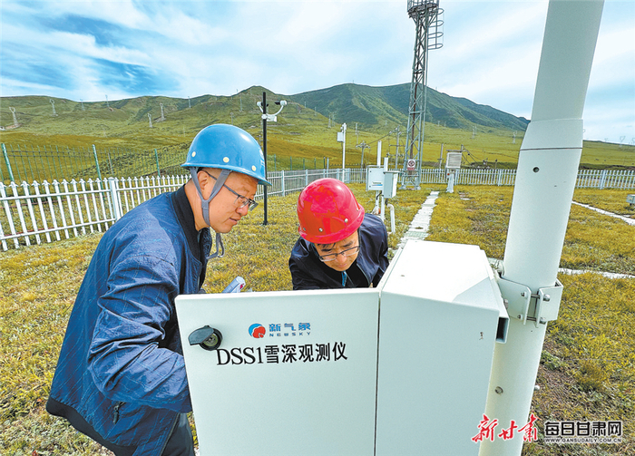 乌鞘岭气象站副高级工程师张弢（左）与同事一起检查雪深观测设备。