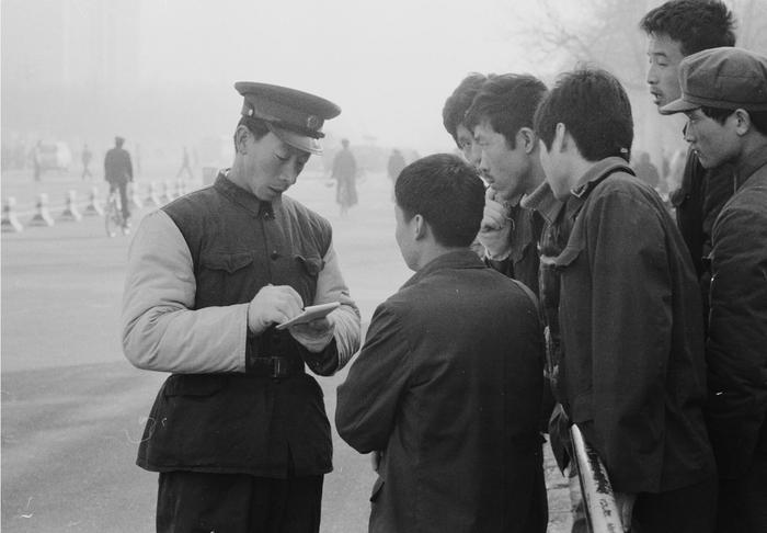 1982年，《北京市道路交通管理暂行规则》实施后，西单路口执勤的交通民警对违章群众进行宣传教育。胡敦志摄