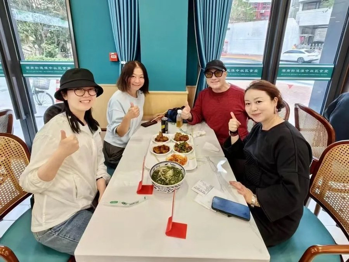 孔祥东（右二）与友人在复8邻里汇社区食堂用餐。徐汇区供图