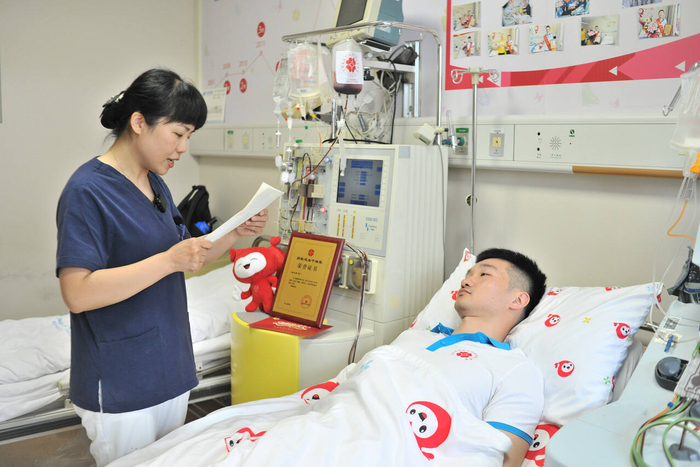 志愿者给赵江涛读受捐者的感谢信。照片由温州市红十字会提供