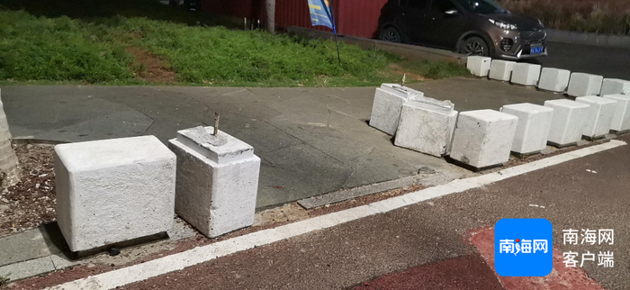 图为西秀海滩亲海步行道与非机动车道间的隔离墩被人私自挪开打开了摊车进出的“口子”。