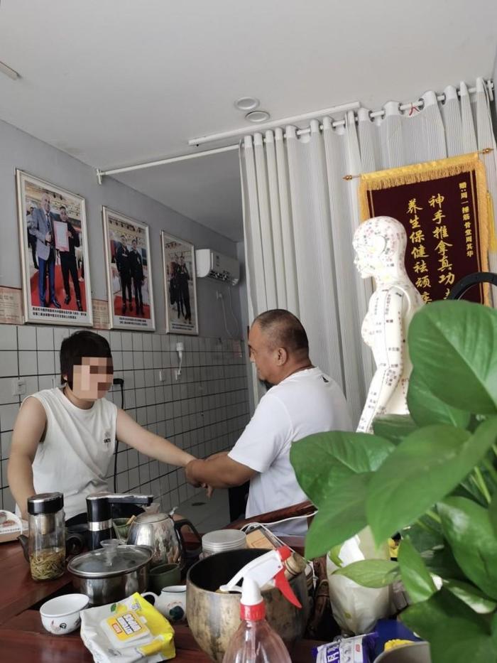 周启华（右一）为患者调理身体