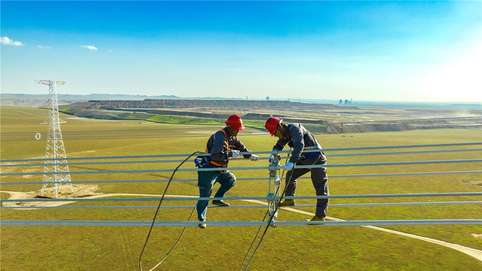 　　工程建设人员在特高压电网进行附件安装作业。徐佳琪 摄