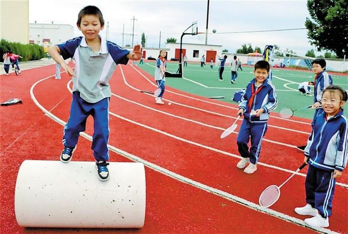 　　小学生在操场上一起玩闹。