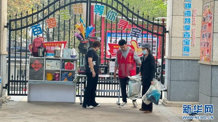 在武汉市青山区中交江锦湾小区的共享百宝箱，居民领取儿童椅。新华网记者 邓楠 摄