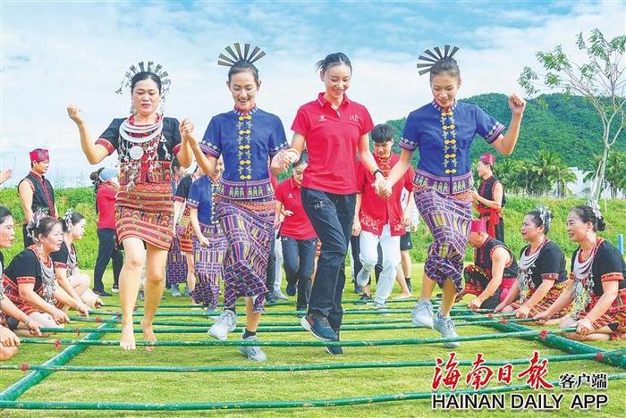 在三亚市吉阳区大茅远洋生态村，海南北京两地代表团的运动员一同跳竹竿舞。海报集团全媒体记者 王程龙 摄