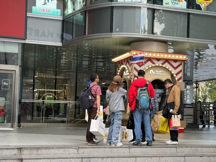 11月23日，正在商场门口聊天等候的泰国旅游团。澎湃新闻记者 唐莹莹 图
