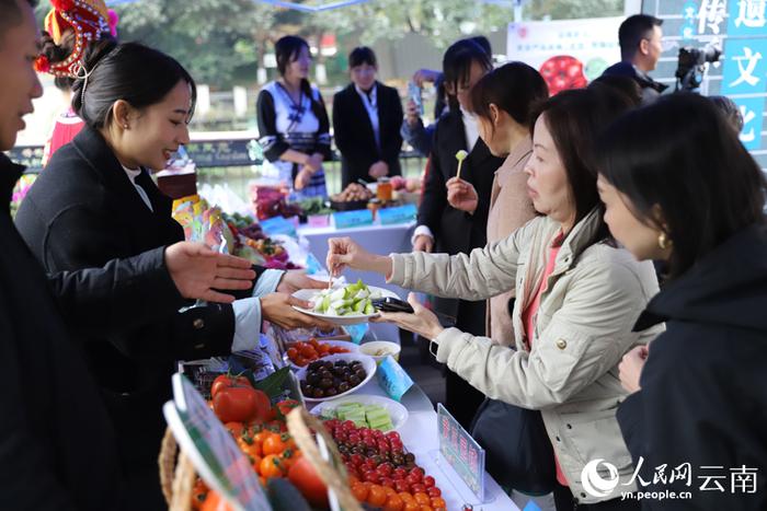 云南元谋城市推介会现场，成都市民品尝元谋蔬果。人民网记者 李发兴摄