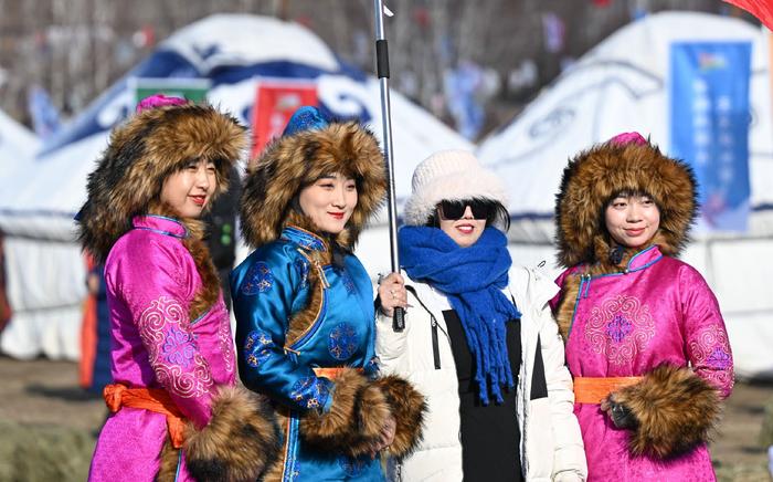 游客（右二）在冰雪节上与演员合影。记者　贝赫　摄