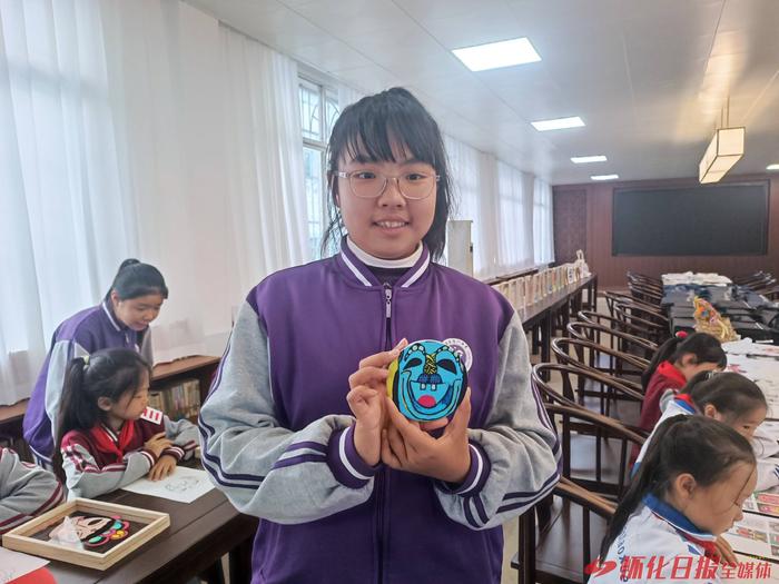 一名学生在沅陵县荷花池小学国学基地展示她的傩文化作品。